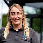 ALDI SÜD Mitarbeiterin im Außenbereich der Filiale lächelt freundlich in die Kamera