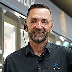 ALDI SÜD Mitarbeiter im Kühlbereich der Filiale lächelt freundlich in die Kamera