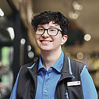 ALDI SÜD Azubi im Kühlbereich der Filiale lächelt freundlich in die Kamera