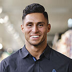 ALDI SÜD Filialleiter steht in der Filiale und lächelt freundlich in die Kamera