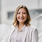 ALDI SÜD Mitarbeiterin in der Verwaltung steht im Treppenhaus und lächelt in die Kamera