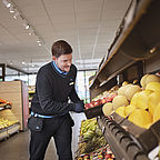 ALDI SÜD Mitarbeiter verräumt eine Palette Äpfel in das Obstregal